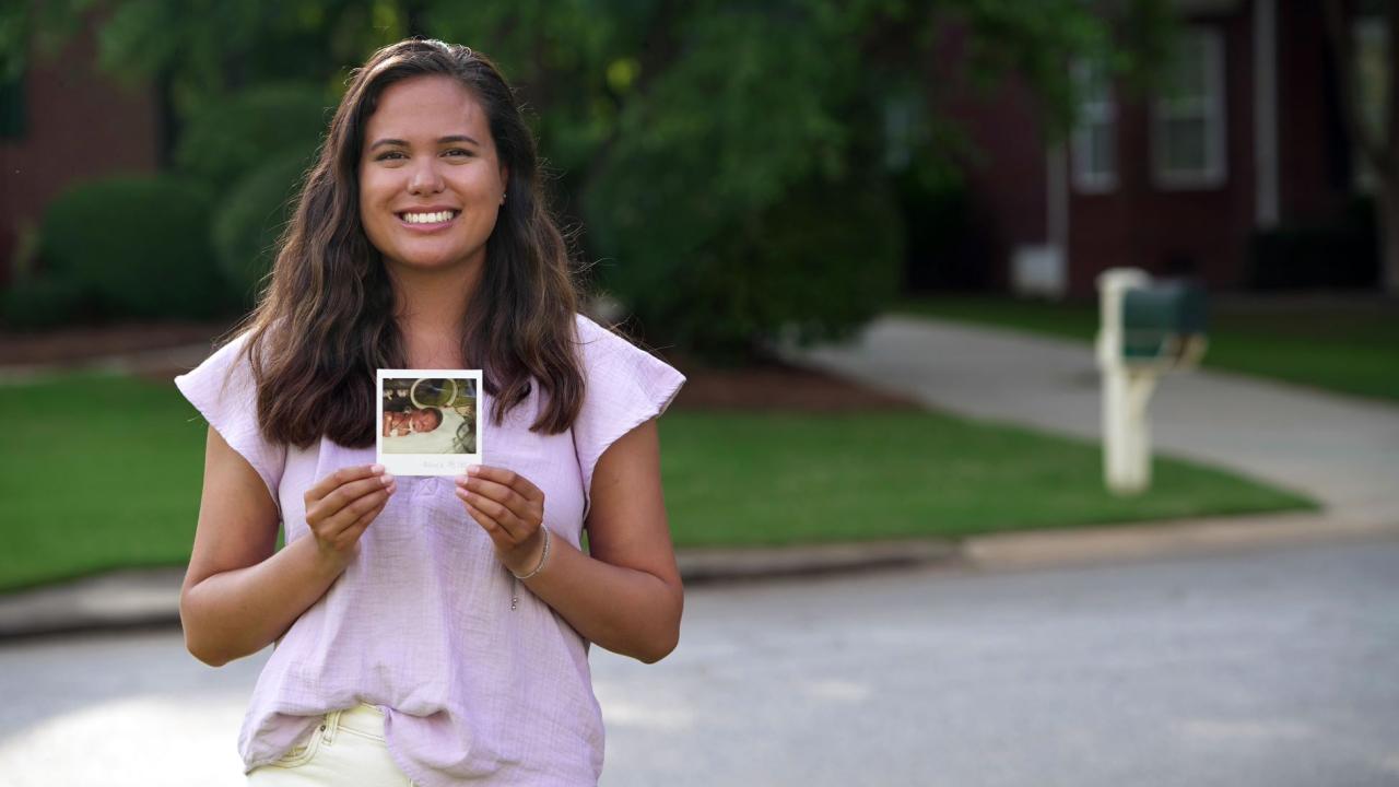 Woman holding up her baby picture